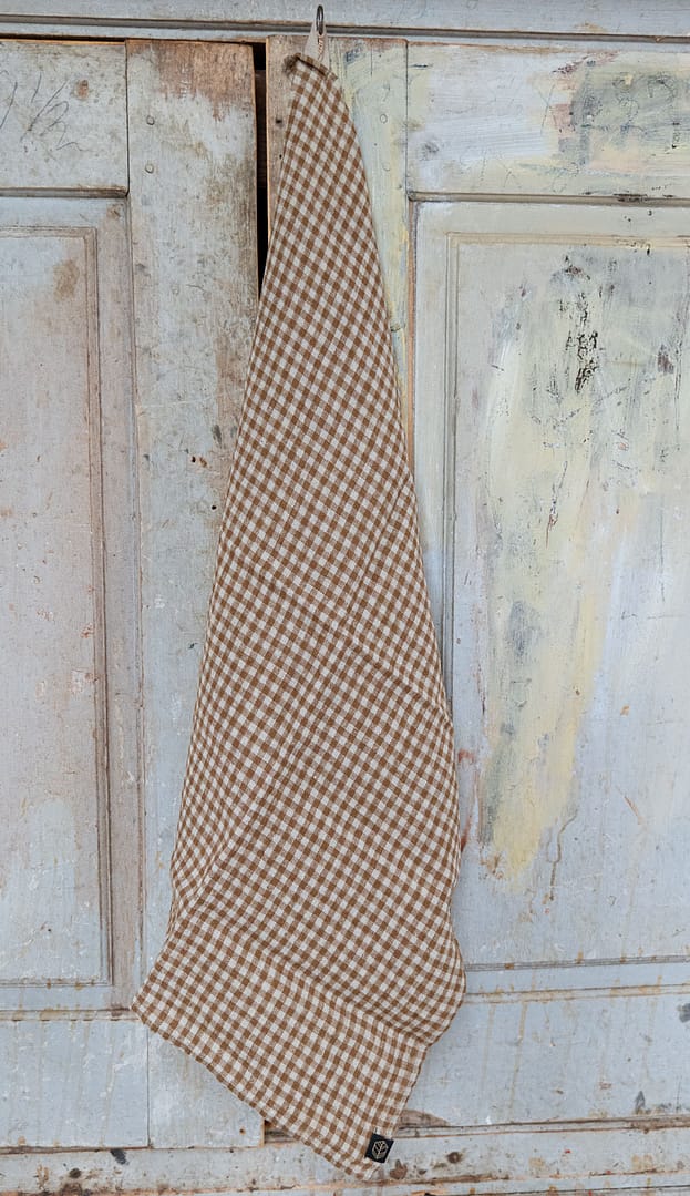 rutig kökshandduk i linne hängande på en krok