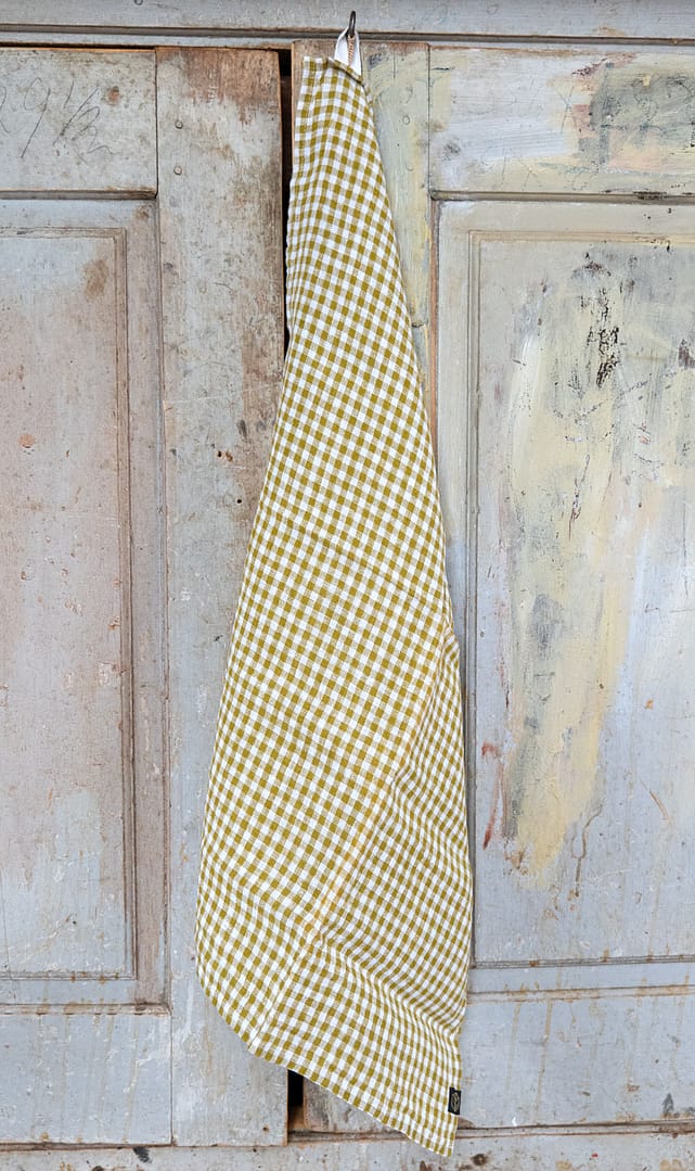 kökshandduk i rutigt linne hängande på en krok