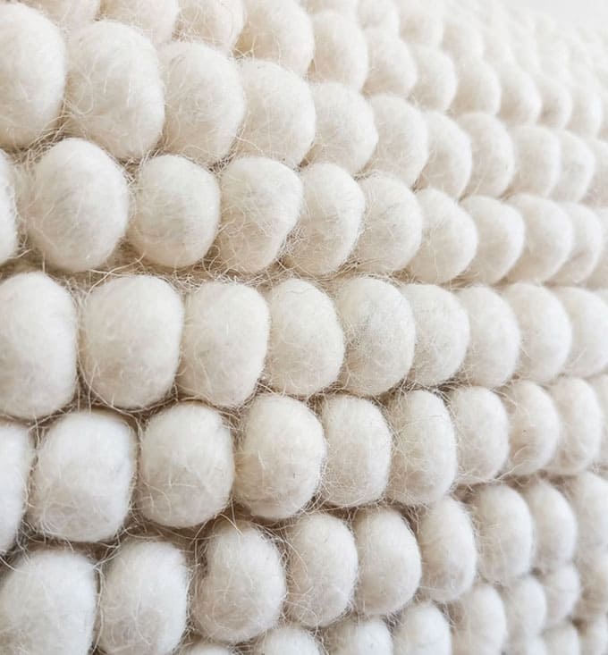 bobblig kudde i ull. Närbild på ytan på kudden i ull med bobblig design.