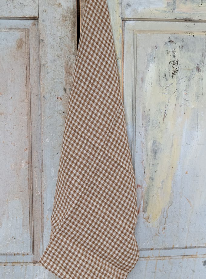 rutig kökshandduk i linne hängande på en krok