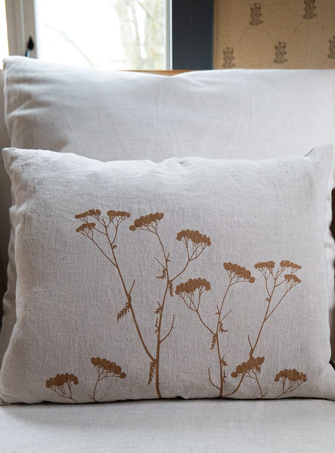 linnekudde i oblekt linne med botaniskt design tryckt i senapsgult