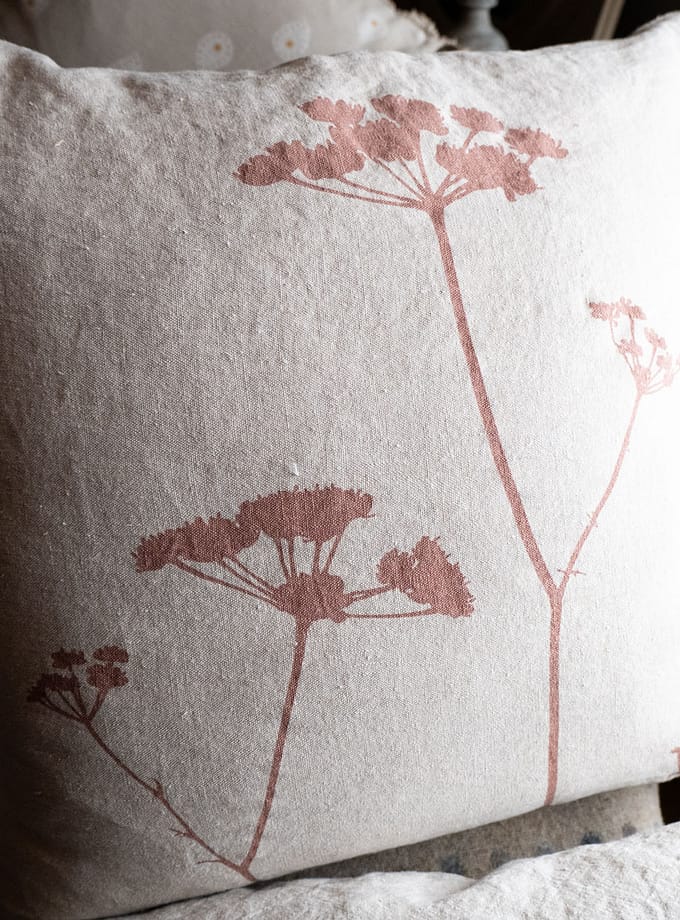 närbild på linnekudde med motivet vildmorot i smutsrosa