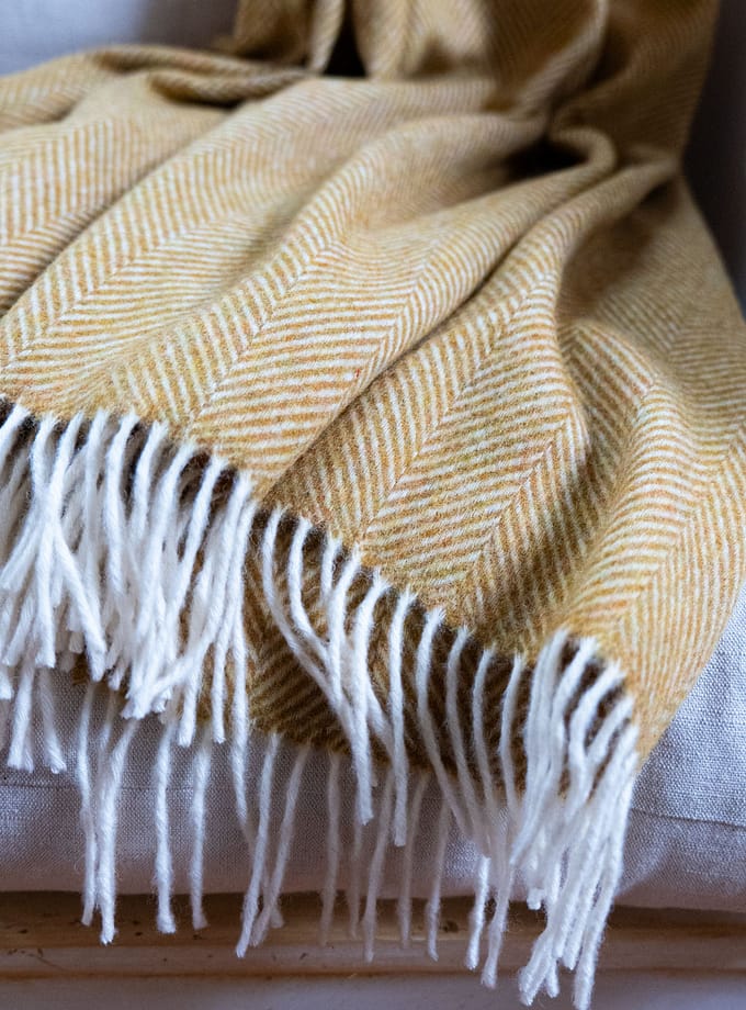 detaljer på gul merionull pläd