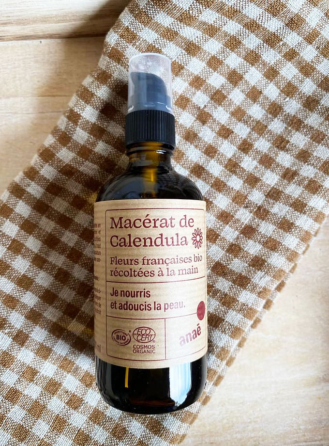 brun glasflaska med calendulaolja och en etikett på franska